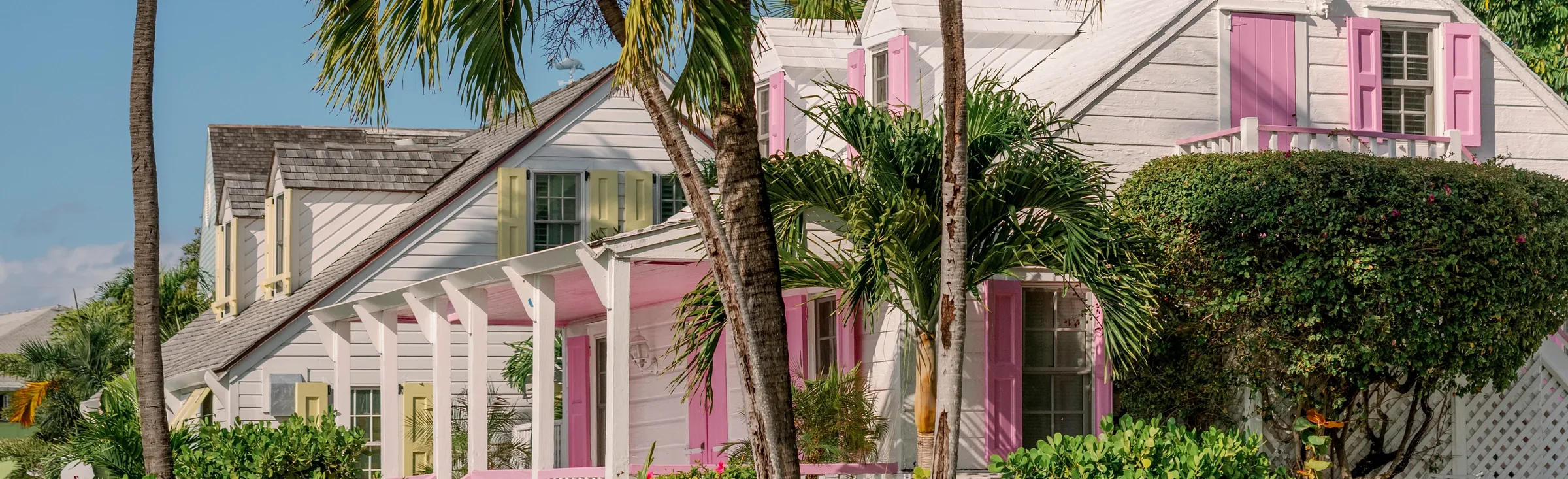 Pastel colonial cottages with pink shutters and palm trees, Harbour Island, Bahamas