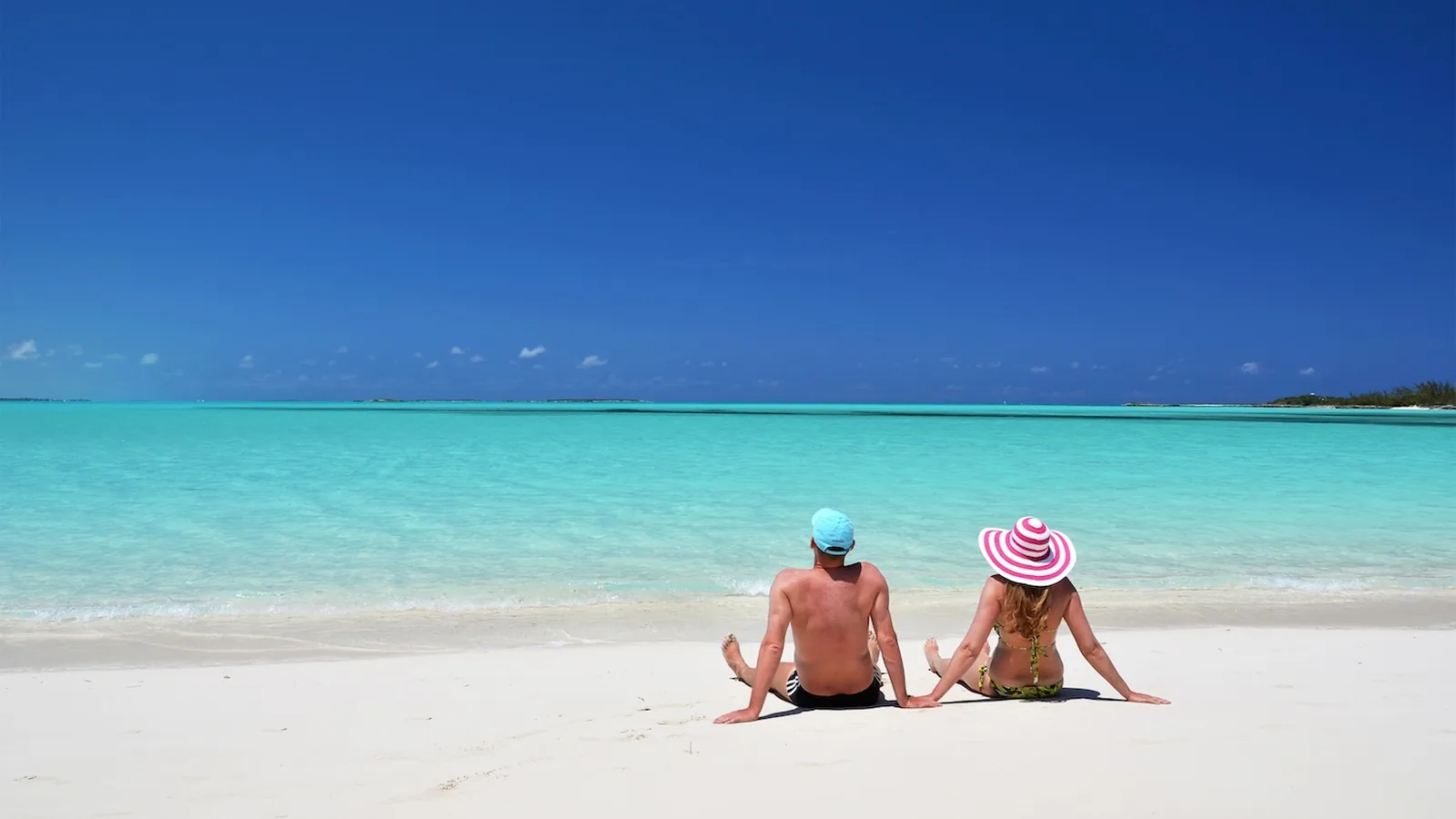 Charter guest couple on a white sand beach with clear water