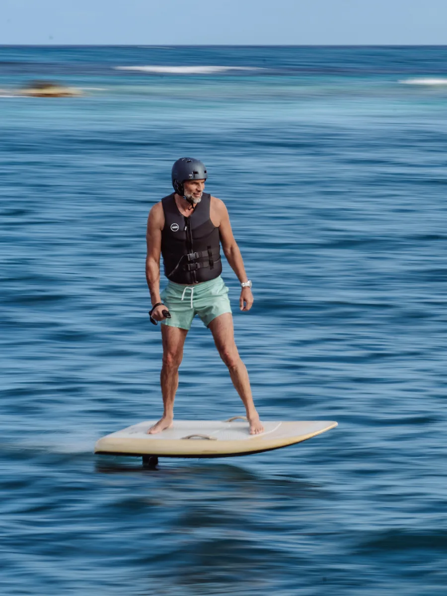 Guest riding an e-foil over turquoise water