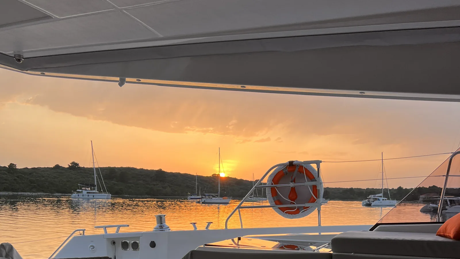 Sunset drinks laid out on a yacht deck at anchor
