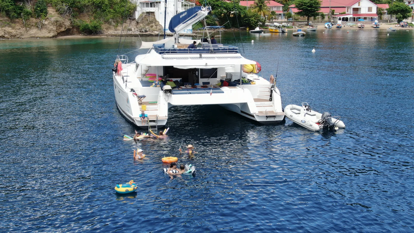Charter guests at the noodle bar behind a Fountaine Pajot Victoria 67, aerial view, Guadeloupe