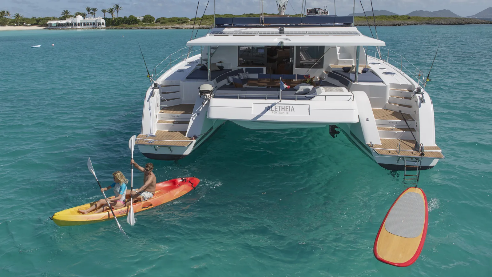 Couple in a kayak beside a Fountaine Pajot Victoria 67 at anchor in Anguilla