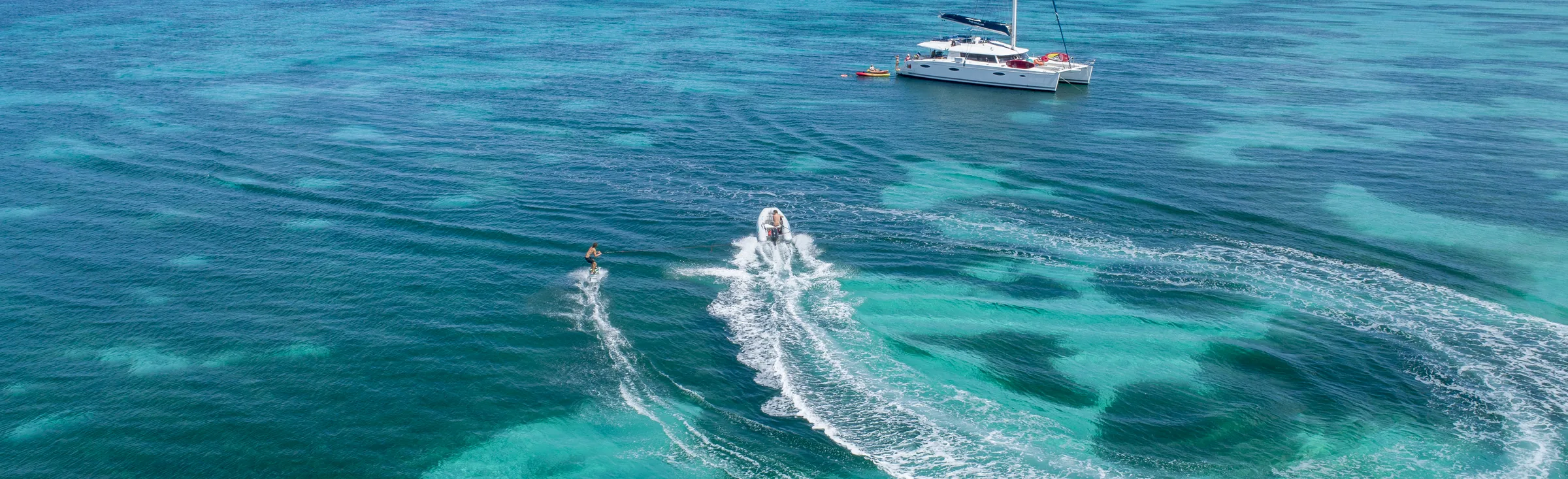 Wake-board behind the tender, aerial view, Anse La Frais, Marie-Galante, Guadeloupe