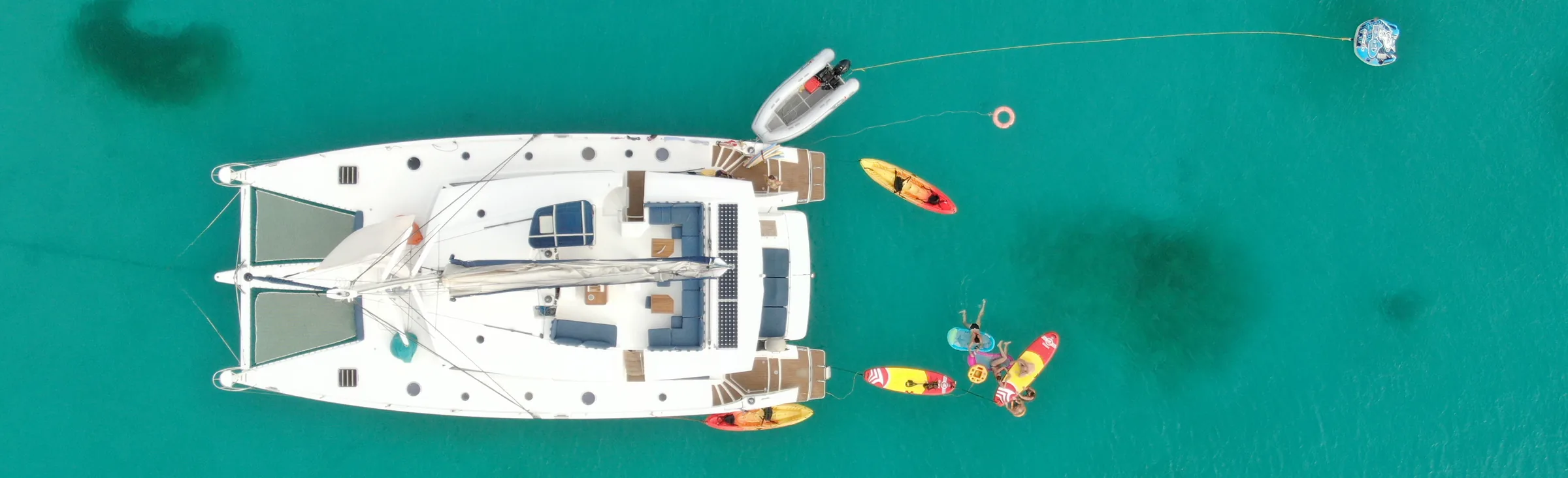 Yacht at anchor off Anse Canot, Marie-Galante, Guadeloupe, aerial view of a Fountaine Pajot Sanya 59 with her water toys out