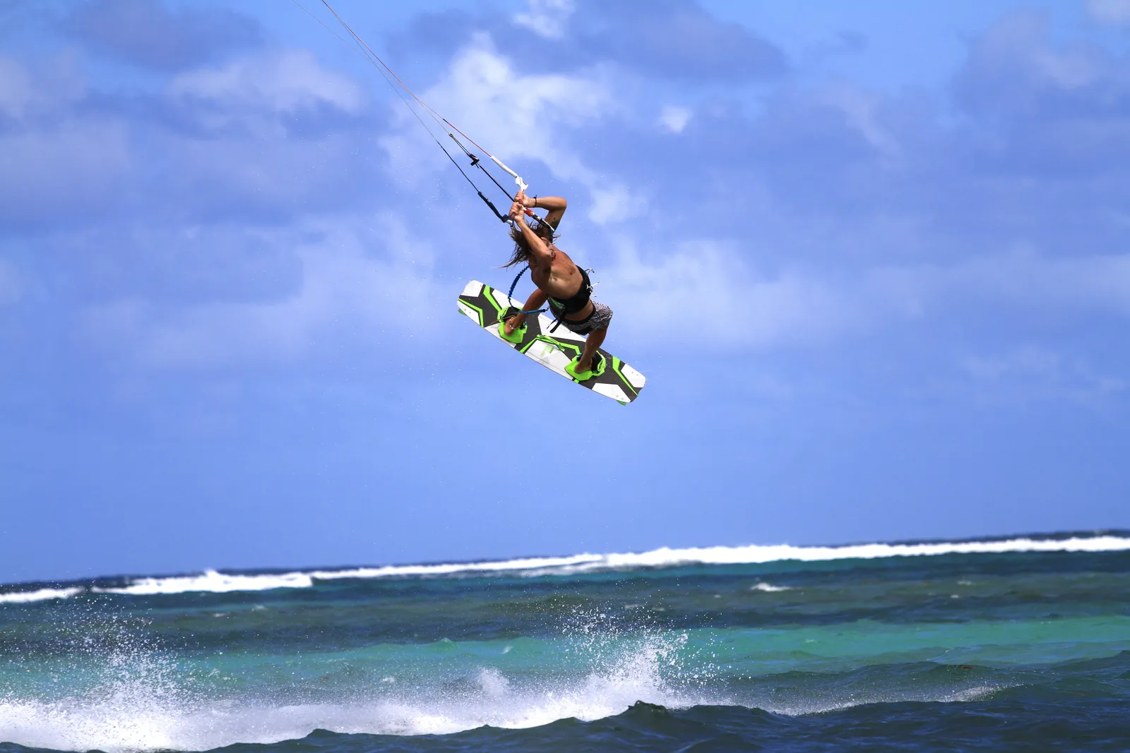Un kitesurfeur sautant par-dessus un récif brisant