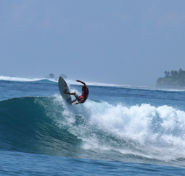 Surfer aux Maldives au niveau de la lèvre de la vague